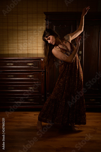 Young girl dancer and singer in gypsy dress dancing and posing on stage