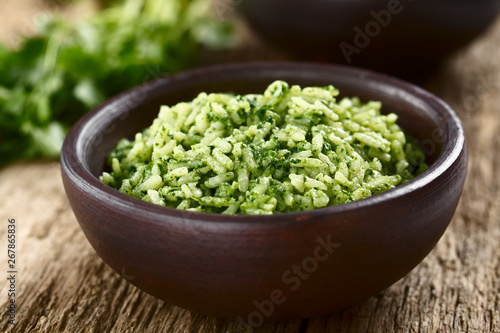 Traditional Mexican Arroz Verde green rice dish made of long-grain rice, spinach, cilantro and garlic, served in rustic bowl (Selective Focus, Focus in the middle of the image)
