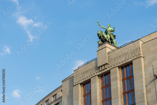 Photography Low angle view of the bronze statue and sculpture on the top of banking tower in Prague, Czech Republic