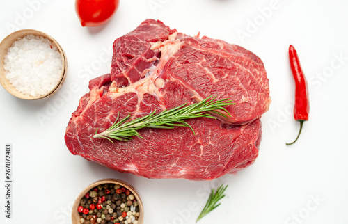 raw beef steak with herbs and spices on a white background, isolate
