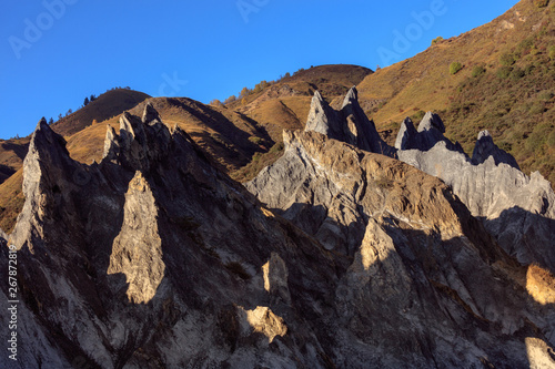 Bamei stone forest, exotic pillars of gray stone situated in the grasslands of Sichuan Province, China. Unique rock formations with clouds in the distant background. Martian Tibetan Landscape photo