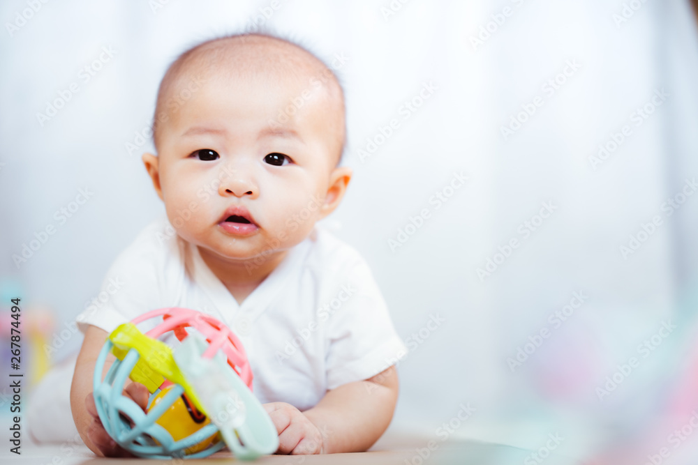 Asian baby happy in the room.Asian baby girl lying down on bed . Asian baby happy in the room.Asian baby girl lying down on bed .