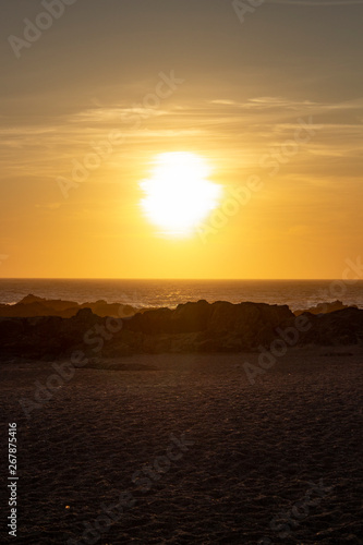 Sunset on the beach with rocks, at Porto, Portugal © Appreciate