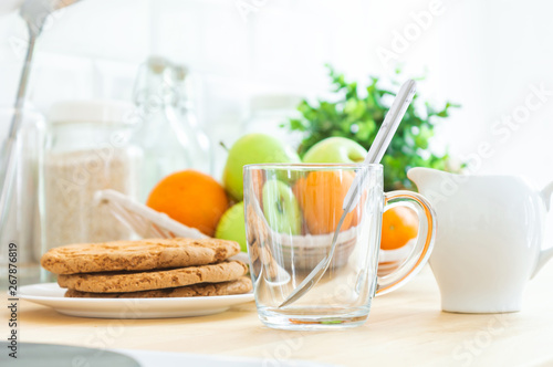 Empty сup, milk jug, cookies and fruit on the kitchen table. Making breakfast, good or healthy morning.