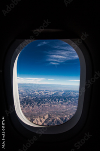 Desert Mountain View with Blue Sky Through an Airplane Window