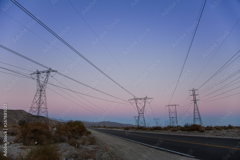 Electric Power Lines over a Desert at Sunset