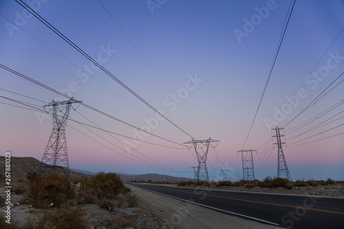 Electric Power Lines over a Desert at Sunset