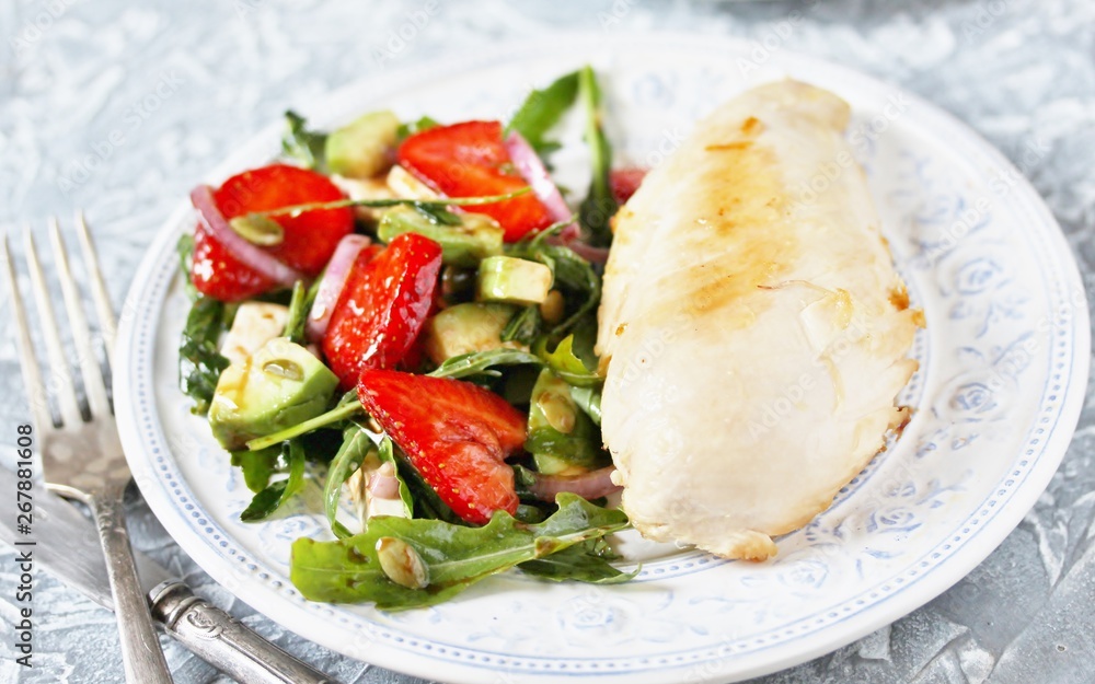 food without carbohydrates - fried chicken breast and salad with strawberries, cheese, avocados, onions and herbs, dressed with oil and balsamic. keto diet. rich in proteins. lunch for keto. food without carbohydrates - fried chicken breast and salad with strawberries, cheese, avocados, onions and herbs, dressed with oil and balsamic. keto diet. rich in proteins. lunch for keto.