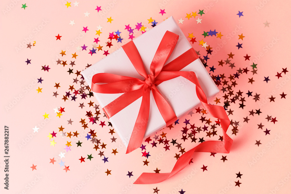 Gift box with ribbon on pink background close-up, top view Gift box with ribbon on pink background close-up, top view
