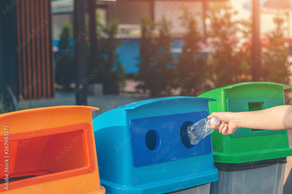 Fototapeta premium Dump the garbage into the blue tank for recycling.