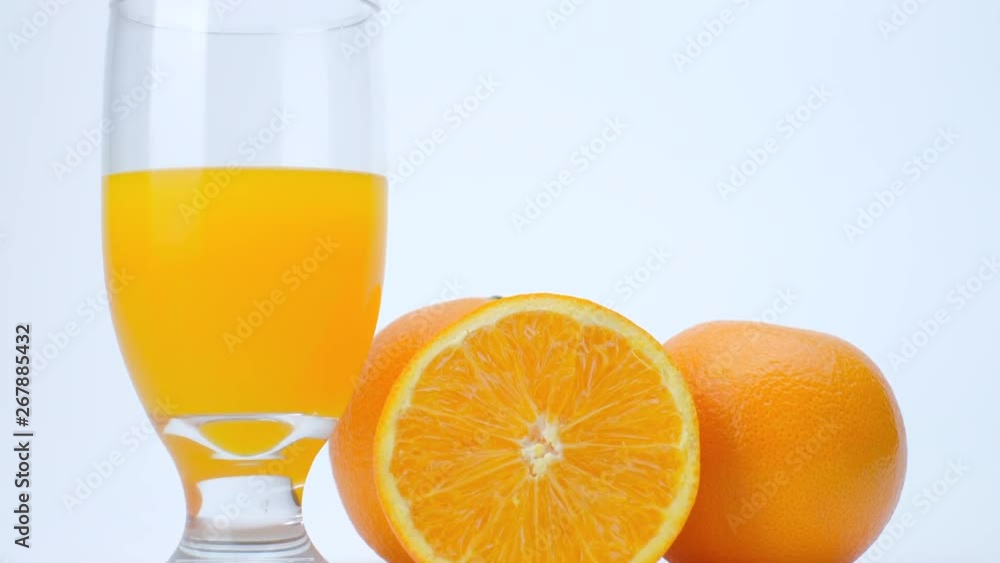4k Slider shot of orange fruit and orange juice on white background. 4k Slider shot of orange fruit and orange juice on white background.