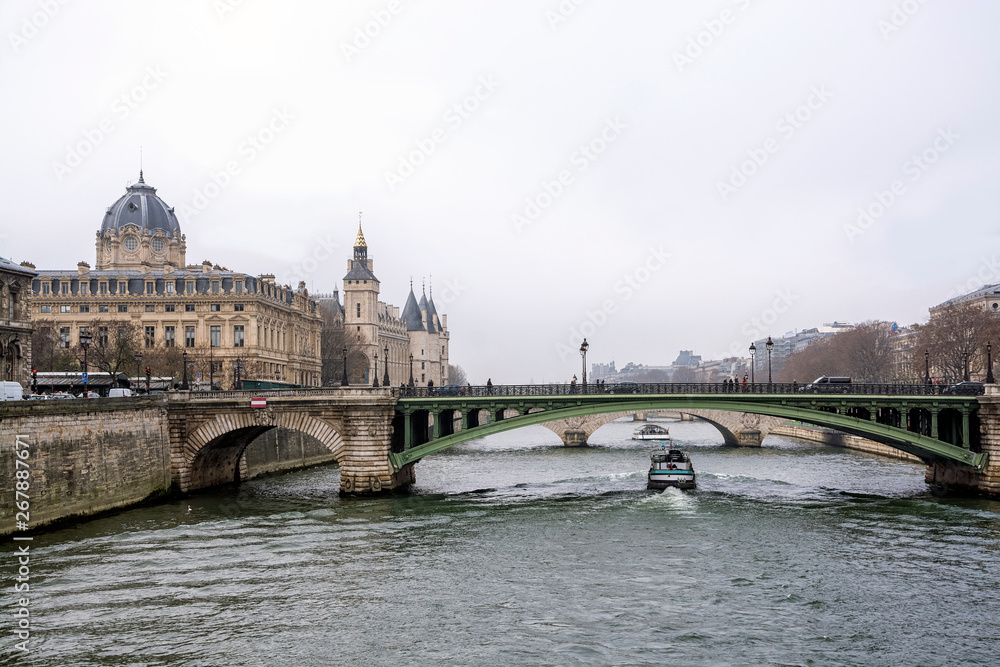 View of the Conciergerie and Seine River in Paris on a cloudy winter day, France