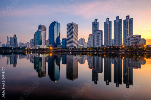 Business district cityscape from a park with sunrise time , Bangkok Thailand.