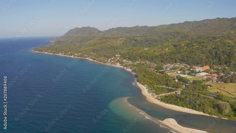 High altitude viewpoint aerial overlooking luxurious, tropical coastline of paradise, Bohol island, Philippines. Coastal buildings & green lush hills & mountains surrounded by turquoise ocean waves. High altitude viewpoint aerial overlooking luxurious, tropical coastline of paradise, Bohol island, Philippines. Coastal buildings & green lush hills & mountains surrounded by turquoise ocean waves.