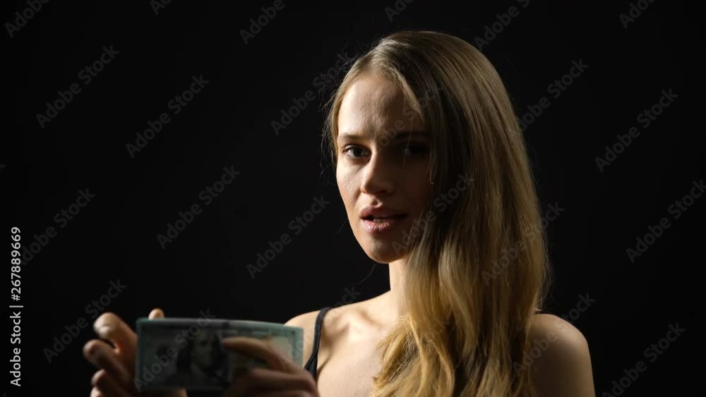 Tricky woman counting big sum of dollars against dark background, money fraud Tricky woman counting big sum of dollars against dark background, money fraud