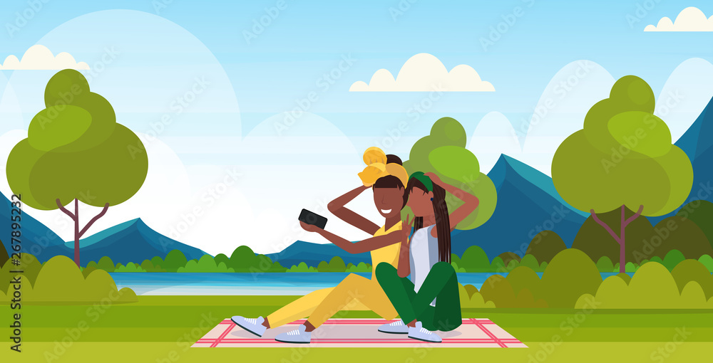 two women taking selfie photo on smartphone camera african american female characters sitting outdoor on grass posing over nature landscape mountains background flat full length horizontal two women taking selfie photo on smartphone camera african american female characters sitting outdoor on grass posing over nature landscape mountains background flat full length horizontal