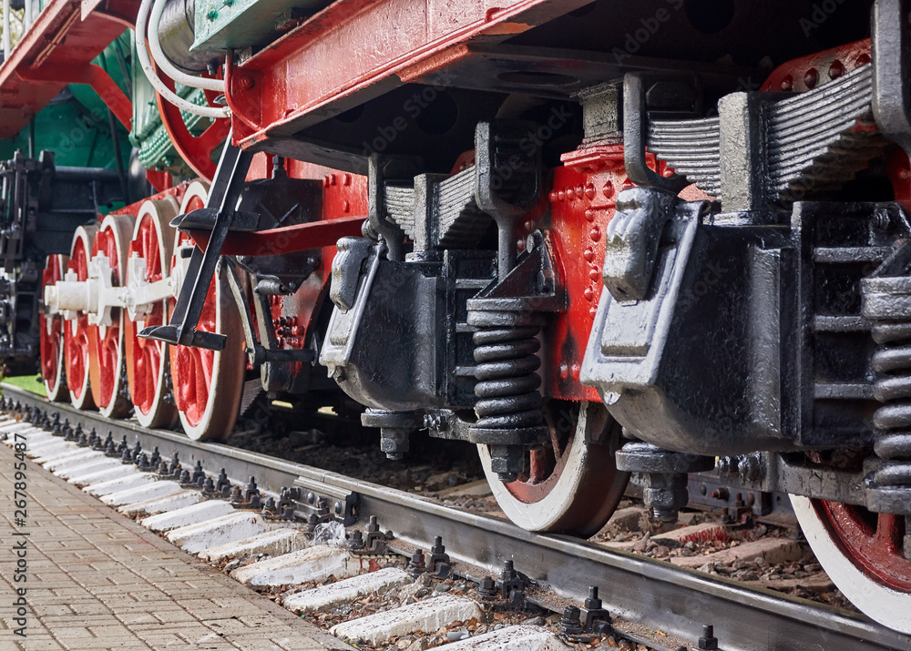 Steel wheels old steam locomotive standing on rails, vintage train, close-up Steel wheels old steam locomotive standing on rails, vintage train, close-up