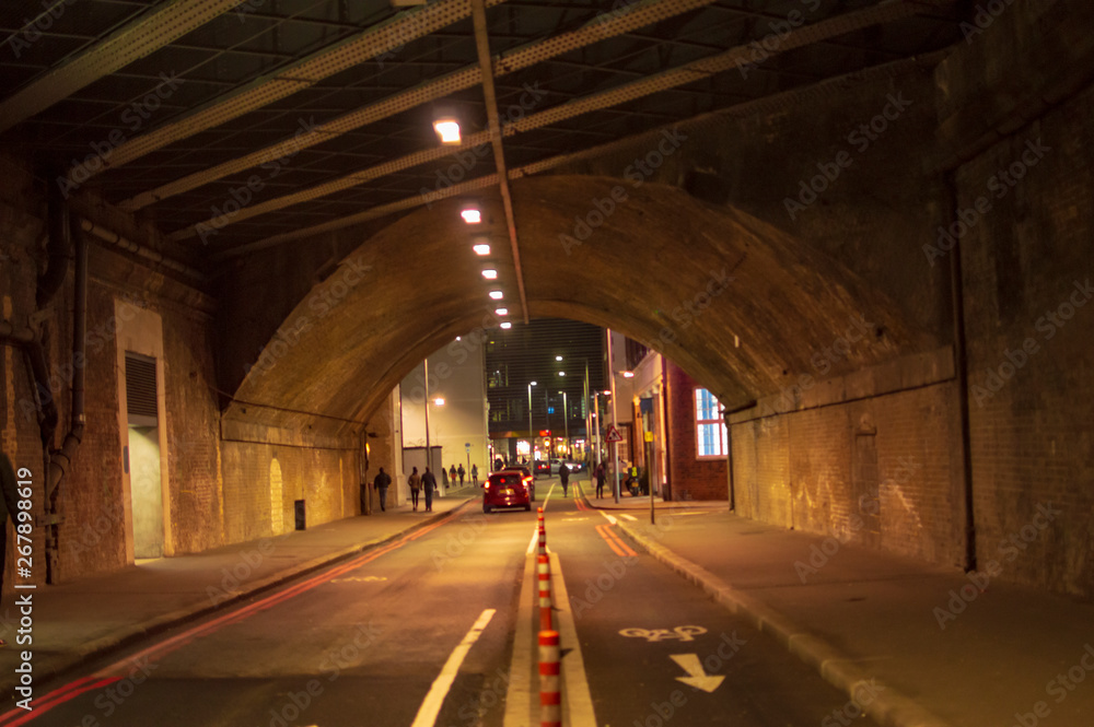 London tunnel with yellow lights with people and cars