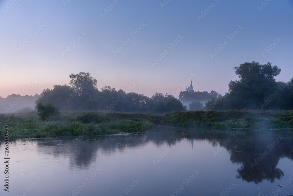Morning landscape on foggy river. Calm and reflection in the water. Country landscape in Russia