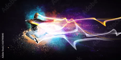 Obraz Nowoczesne tancerz kobieta skoki w bluzę z kapturem z kolorowe plamy tło. Różne środki przekazu