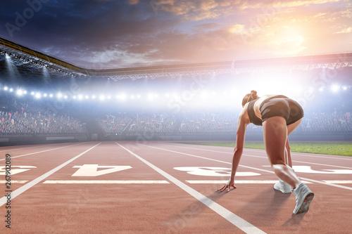 Woman sprinter start ready position on a stadium