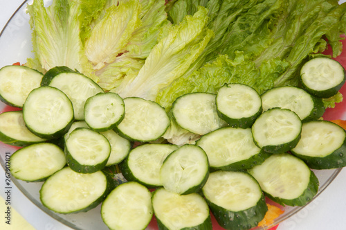 Multiple sliced cucumbers on a white plate