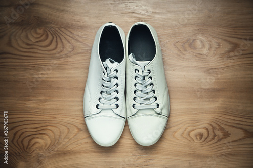 White sneakers on a wooden background.