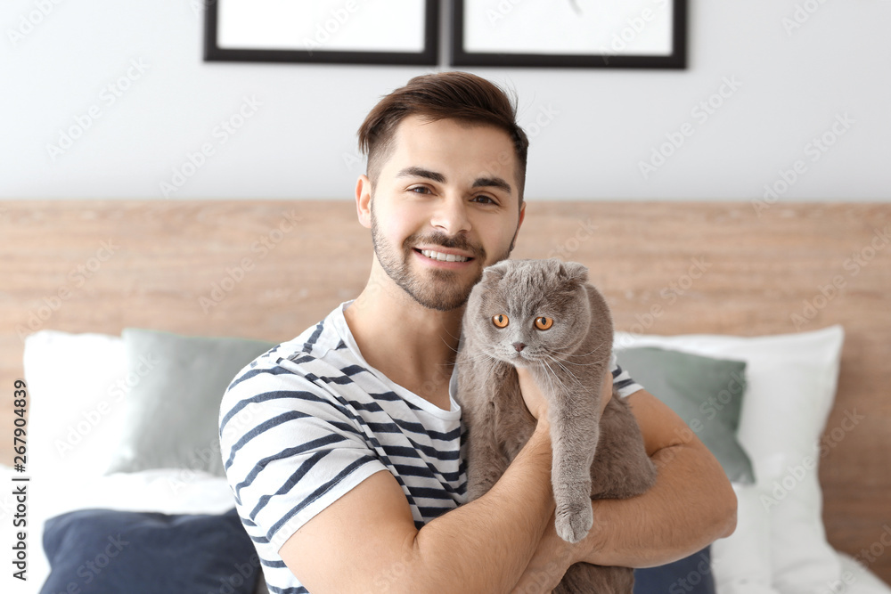 Young man with cute funny cat at home Young man with cute funny cat at home