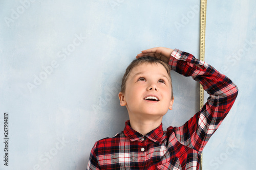 Cute little boy measuring h...