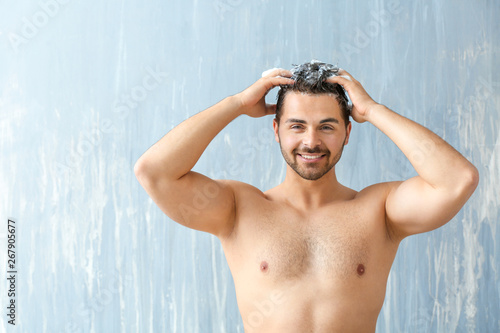 Handsome man washing hair o...
