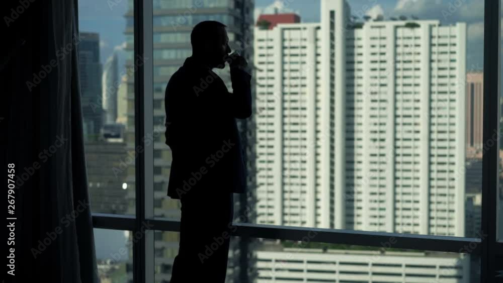 Young businessman drinking coffee and admire view from window at office Young businessman drinking coffee and admire view from window at office