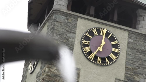 Shift focus on spring water to clock tower in Zermatt town