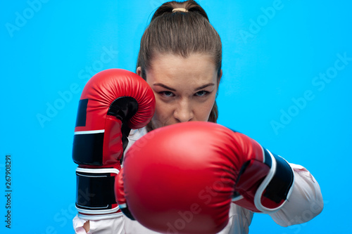 Strong and confident businesswoman wearing blouse and boxing gloves. © pavel_shishkin