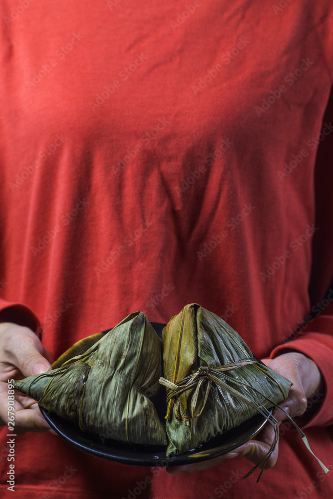 A woman is giving zongzi(rice dumpling) to others as a present on Dragon Boat Festival, Asian traditional food, A woman is giving zongzi(rice dumpling) to others as a present on Dragon Boat Festival, Asian traditional food,