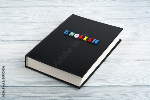 book on a white wooden table, multi-colored letters.