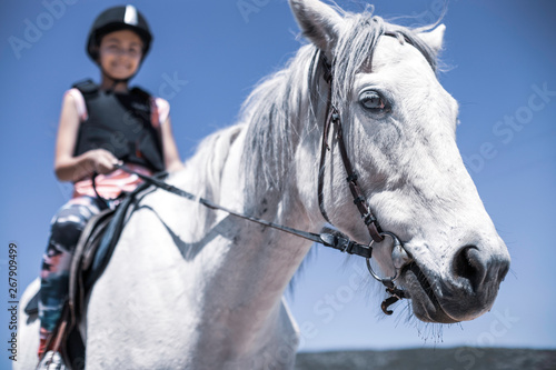 10 years old girl is riding a white horse