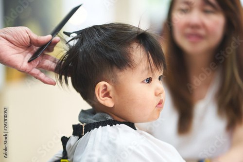 Mom looking her boy haircutting.