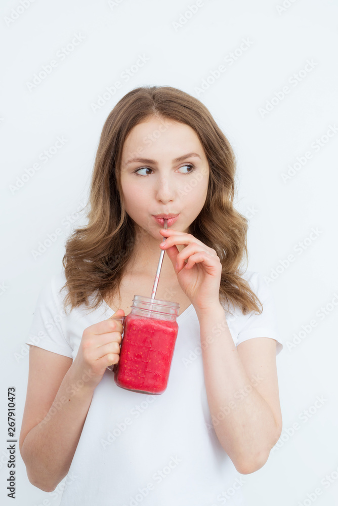 Beautiful happy young girl drinks organic berry, fruit smoothie on a white background. Beautiful happy young girl drinks organic berry, fruit smoothie on a white background.