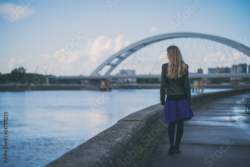 Adult woman walking at quay in the city.