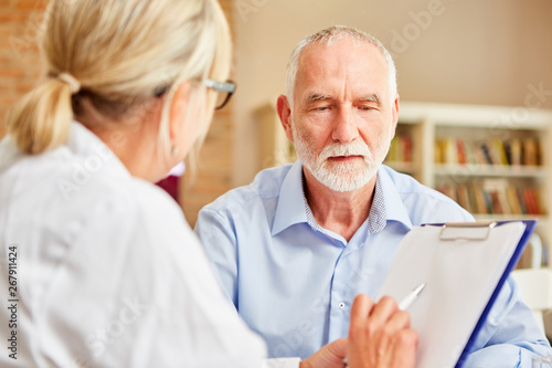 Ärztin befragt Senior als Patient in der Anamnese photo
