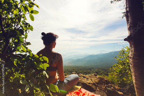 A girl is meditating on the edge of a cliff near the Lago-Naki plateau, Adygea, Russia photo