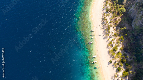 Tropical white sand beach. Island with a blue lagoon. Boats and people off the coast of a tropical island.Vacation on a tropical beach, top view aerial view