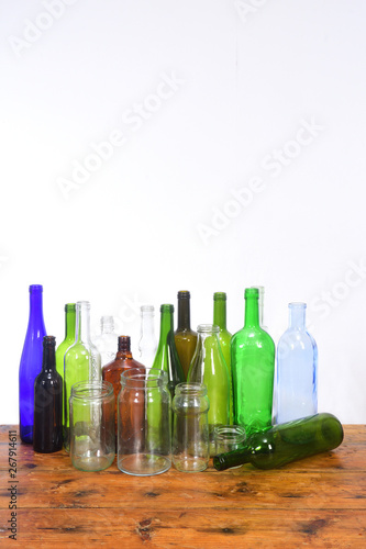 group of bottles and glass jars on a wooden table with white background