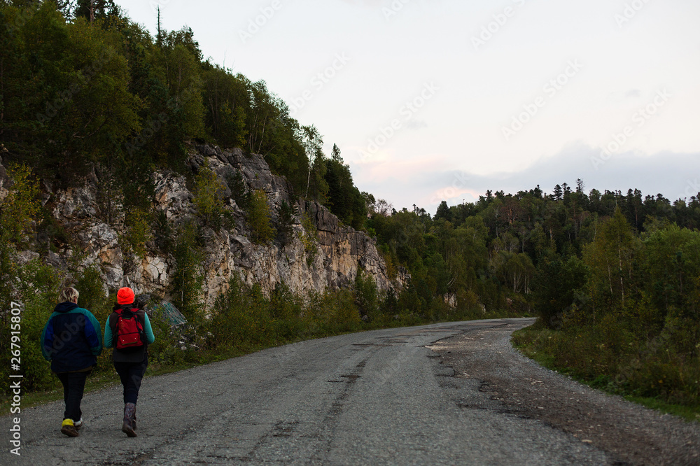 Two girls traveler go on the road to the plateau Lago-Naki