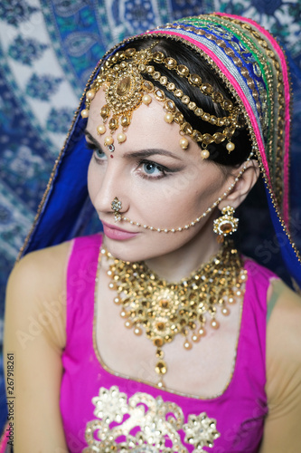 Portrait of a female model in ethnic indian costume with jewellery and traditional makeup.