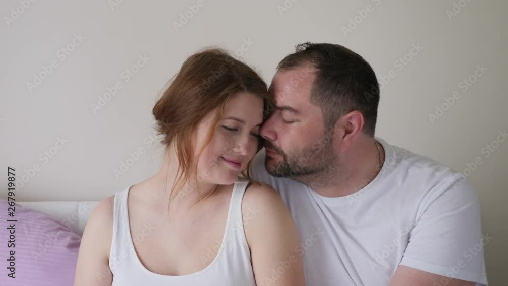 pregnant girl and man in white t-shirts sitting pregnant girl and man in white t-shirts sitting