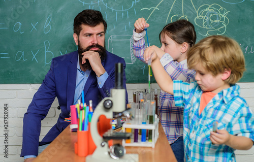 Early development of children. back to school. microscope optical instrument at science classroom. happy children & teacher. learn using microscope at school lesson. Curious teacher working at school.