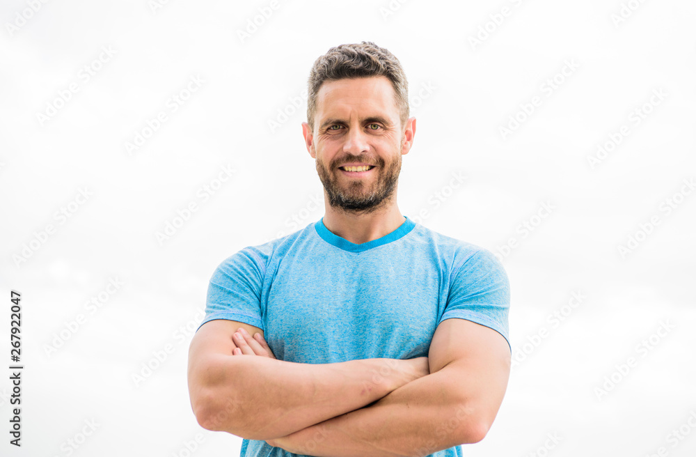 muscular male with beard. happy man isolated on white. sportsman with athletic body. coach in fitness gym. after workout. man athlete in blue sport tshirt. sportswear fashion. happy smiling man muscular male with beard. happy man isolated on white. sportsman with athletic body. coach in fitness gym. after workout. man athlete in blue sport tshirt. sportswear fashion. happy smiling man