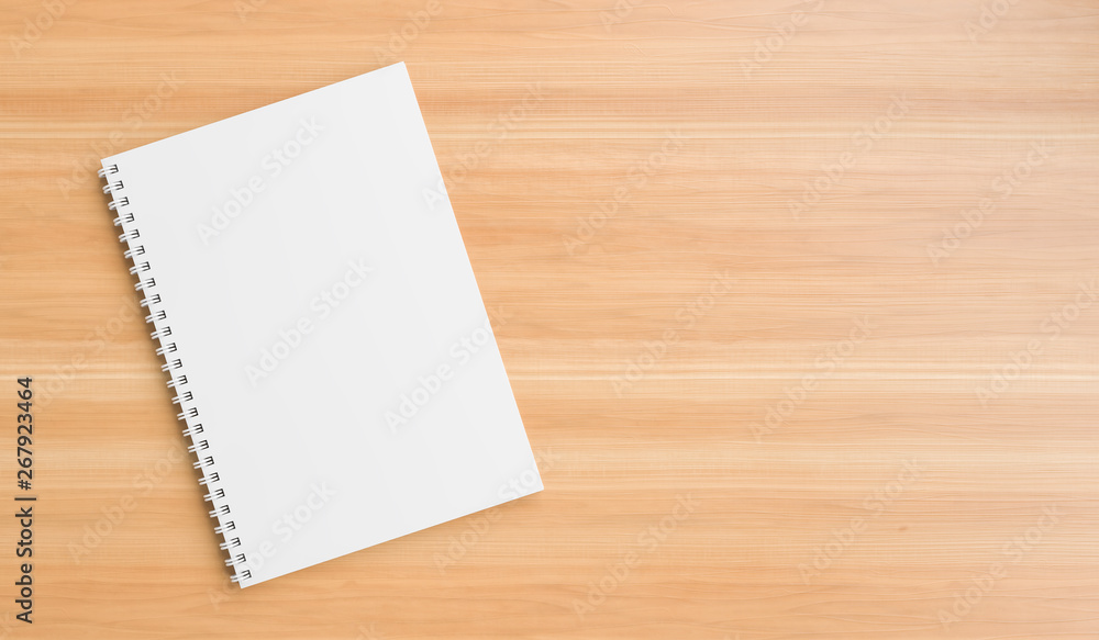 A4 format spiral binding notebook mock up on wooden table A4 format spiral binding notebook mock up on wooden table