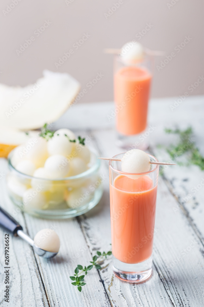Italian alcoholic liqueur made from sweet ripe melon with fresh melon over white wooden background Italian alcoholic liqueur made from sweet ripe melon with fresh melon over white wooden background